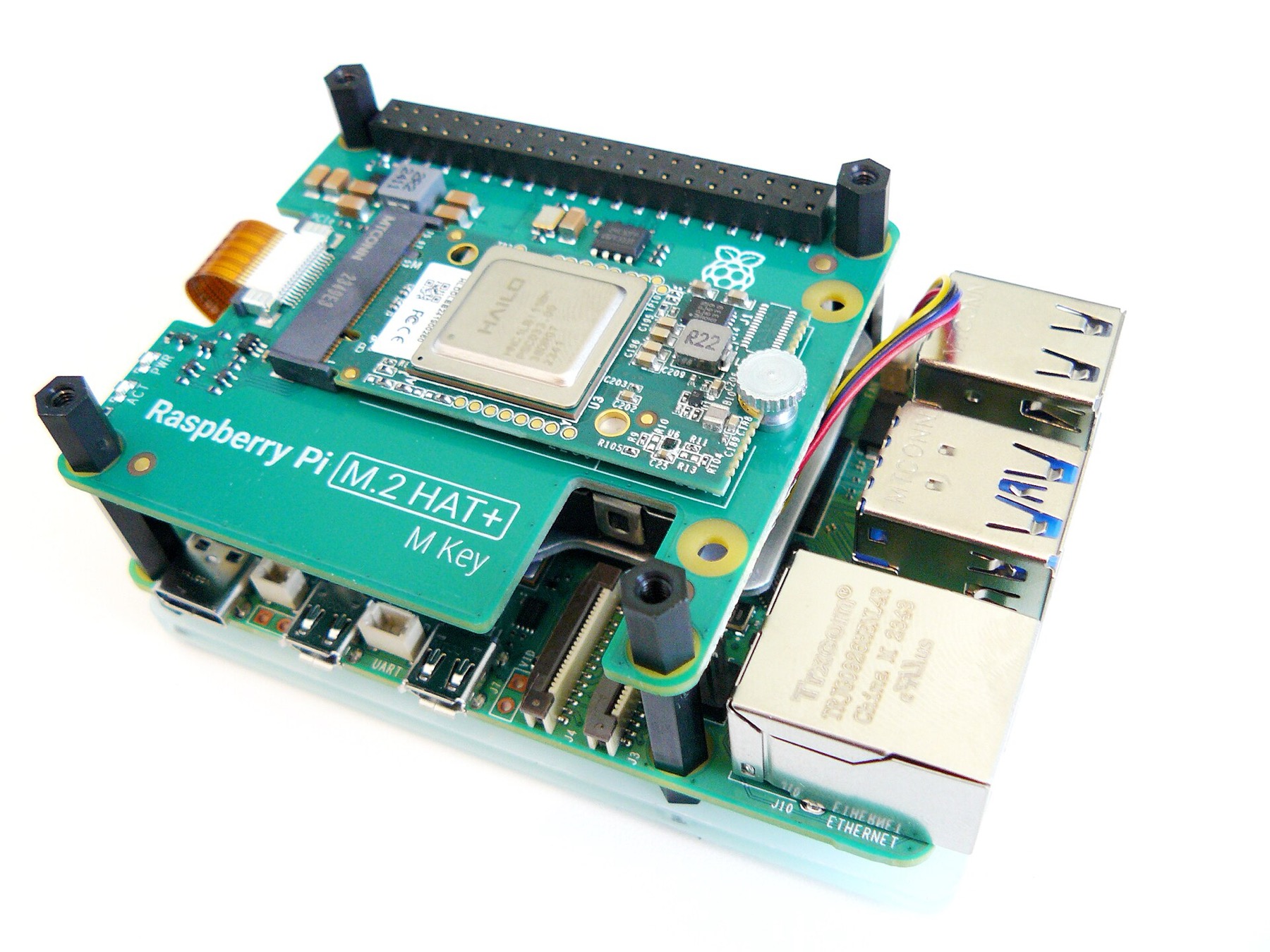 A green circuit board stack: a Raspberry Pi 5 with an add-on board carrying a small chip marked Hailo